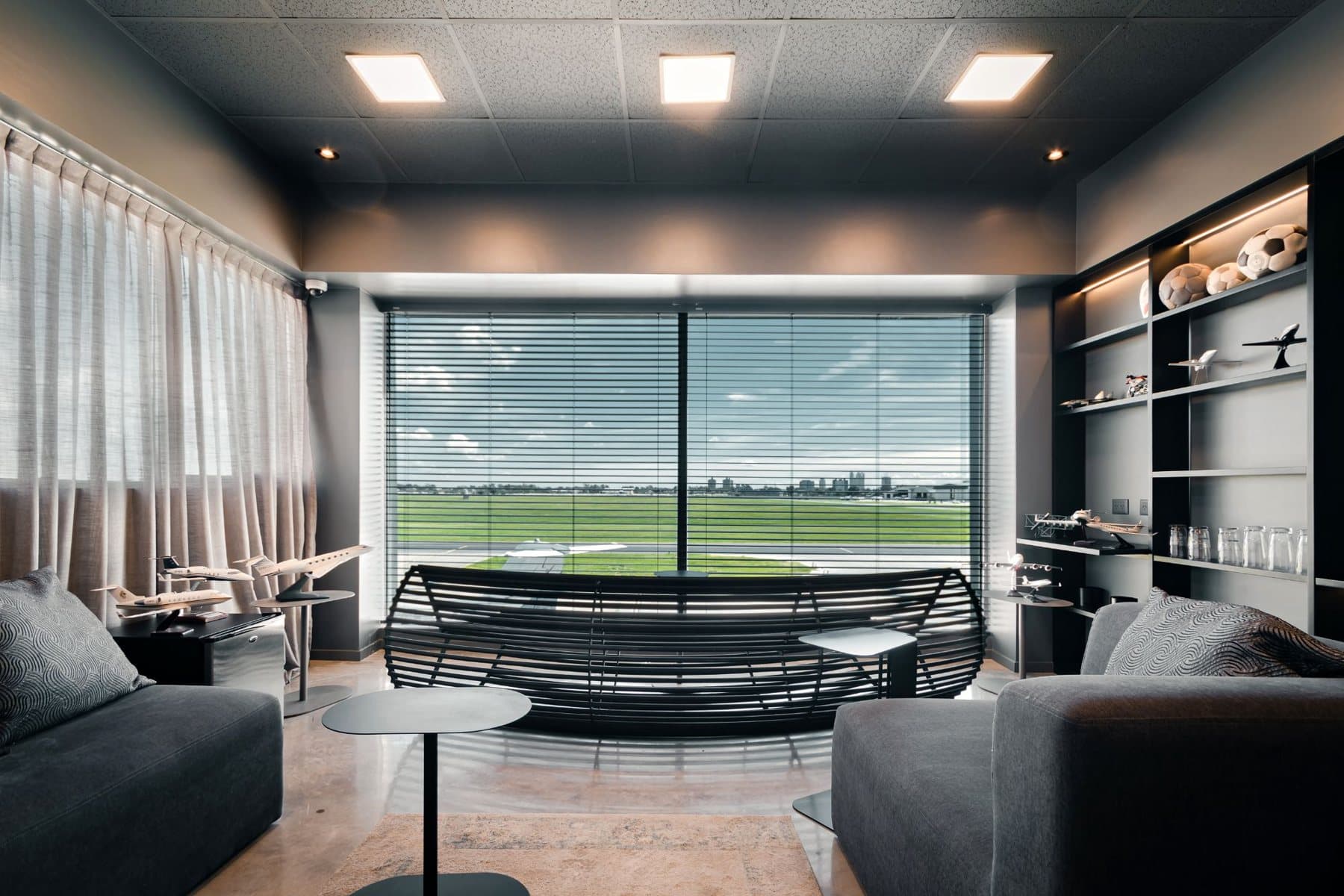 Lounge del FBO con un ventanal a la pista de San Fernando