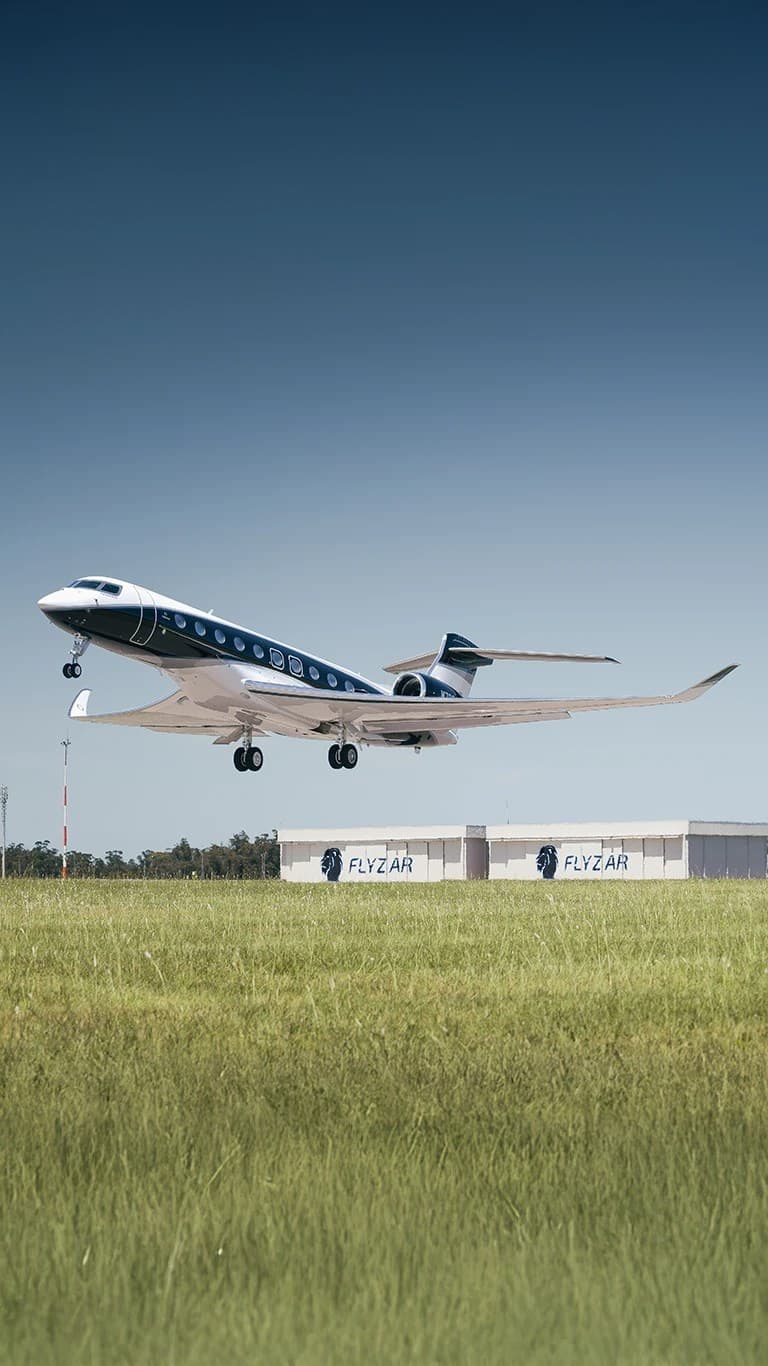 Jet privato in decollo sopra il prato dell'aeroporto